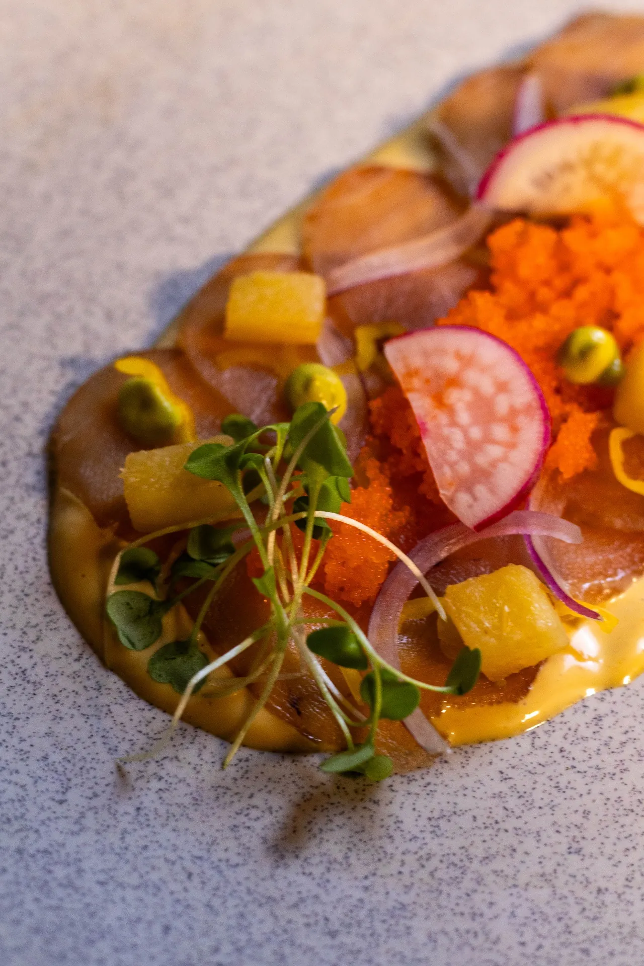 Plato fresco con pescado, tobiko, vegetales y salsa amarilla