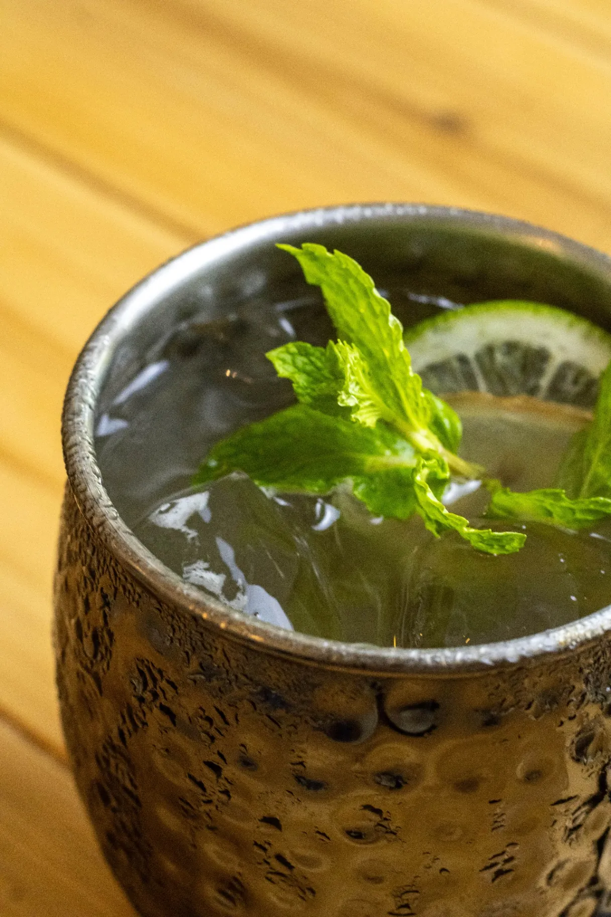 Coctel refrescante con menta y lima en jarra martelada