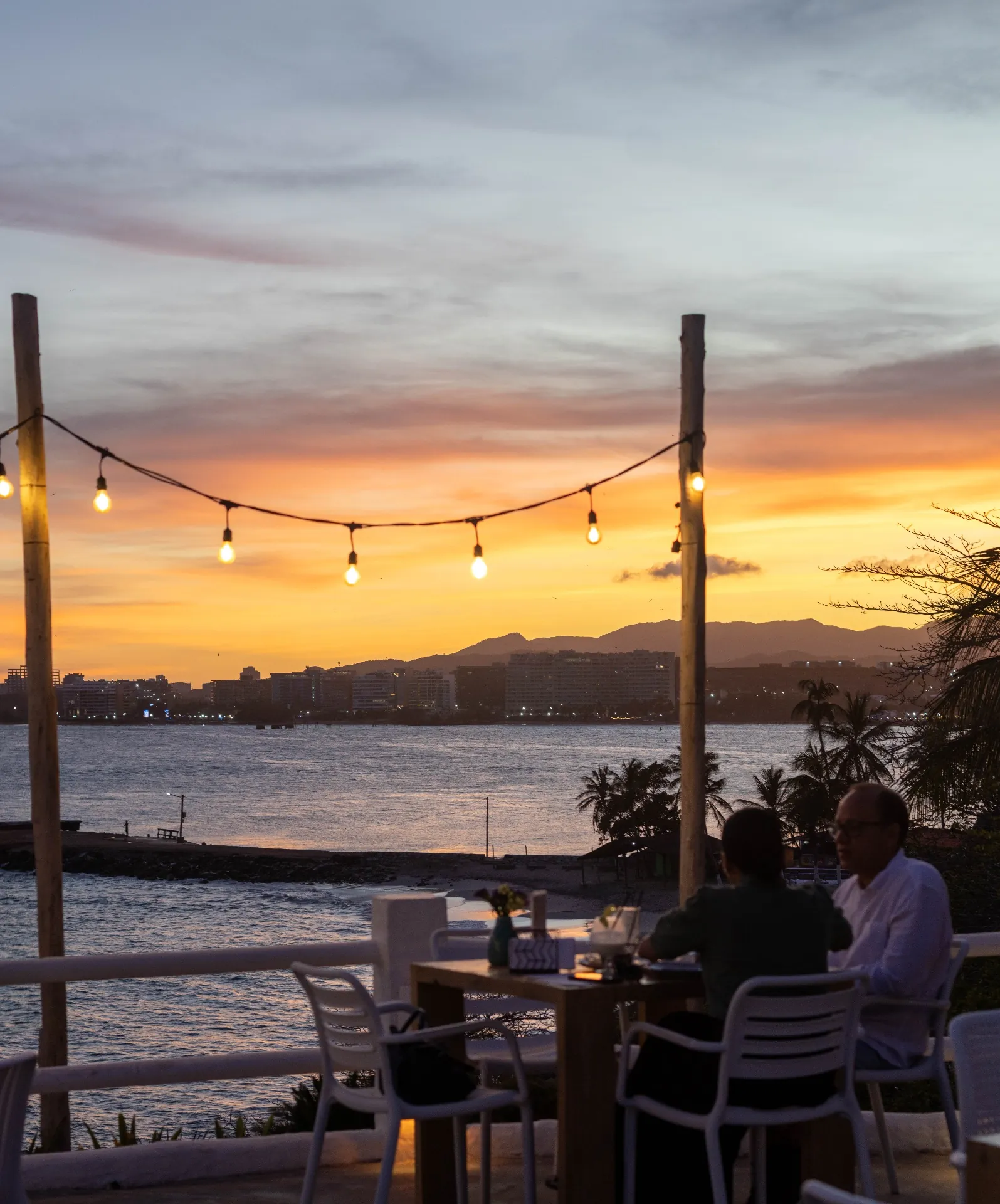Terraza de Guayoyo al atardecer con vista a la bahía